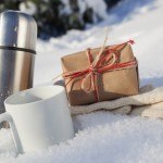 thermos cup and gift in the snow