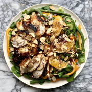 salad with chicken and almonds on plate with marble background