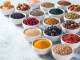 Various superfoods in bowl on gray background