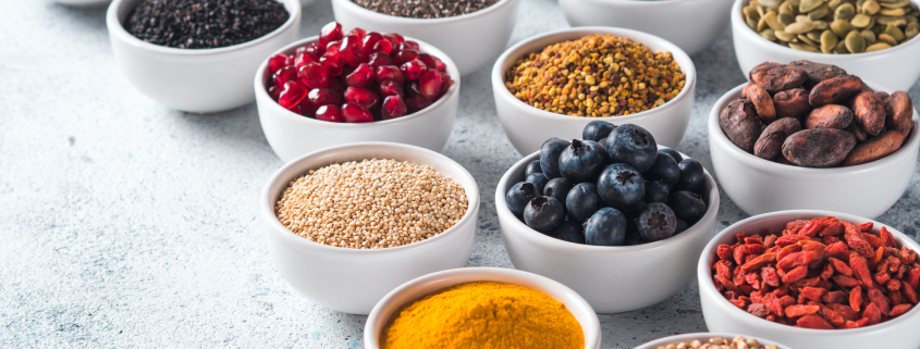 Various superfoods in bowl on gray background