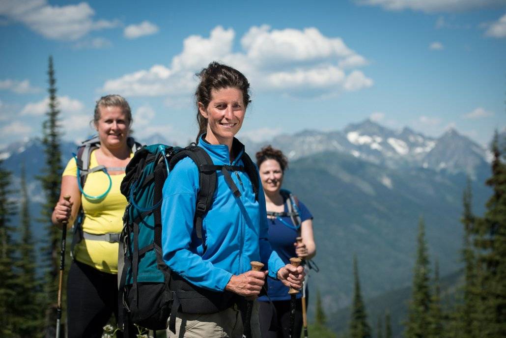 Woman hiker standing in front of mountains at a fitness retreat