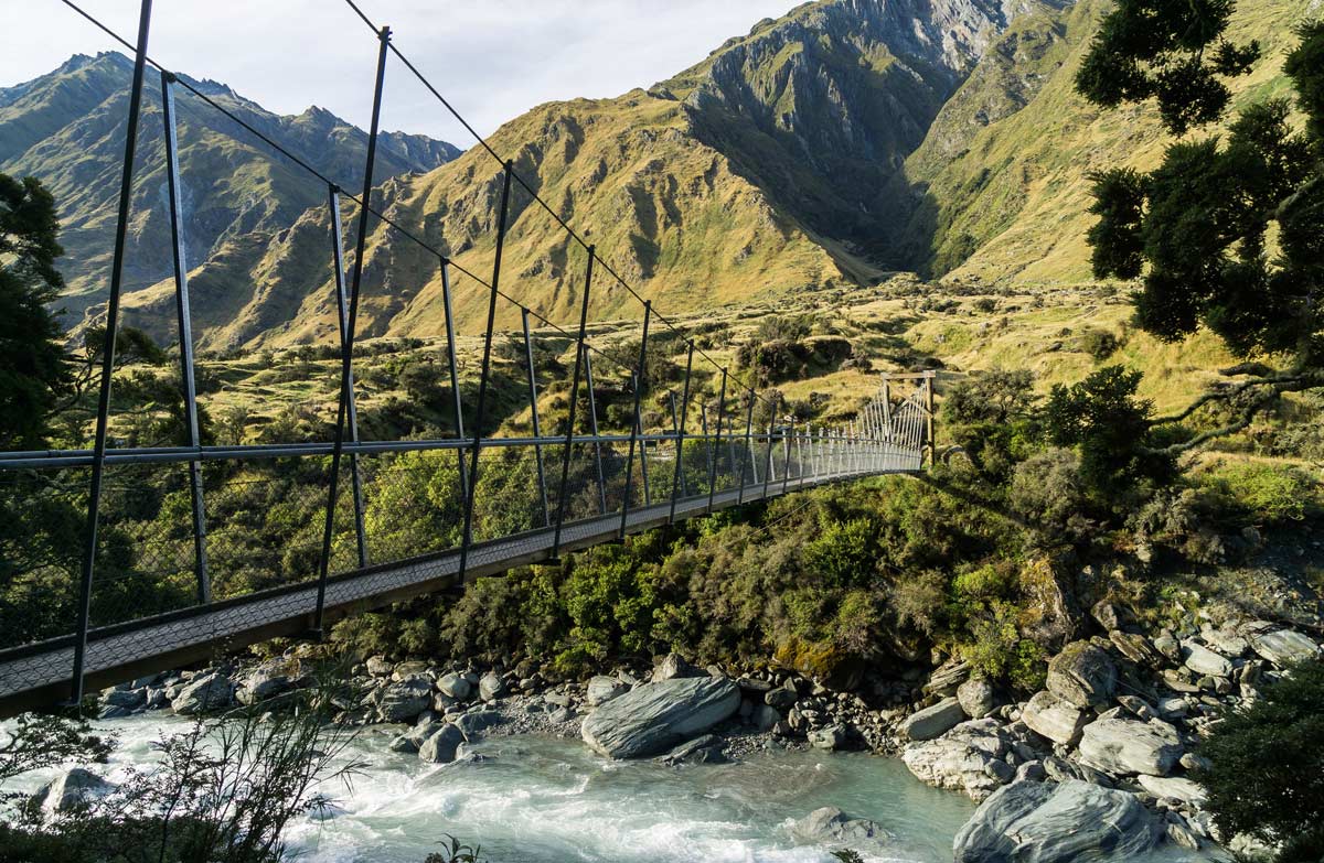 a suspension bridge over a river at the Rob Roy Hike New Zealand Adventure Trek Mountain Trek