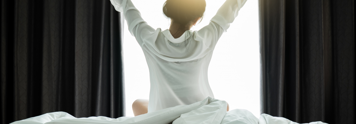 a woman waking up and stretching her arms