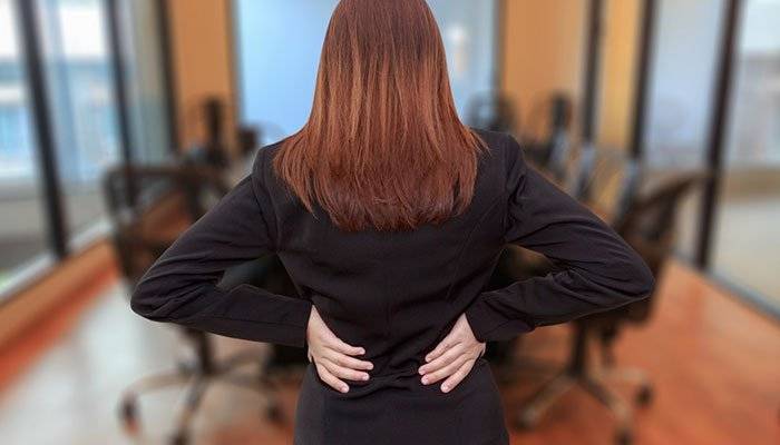 woman holding her lower back pain